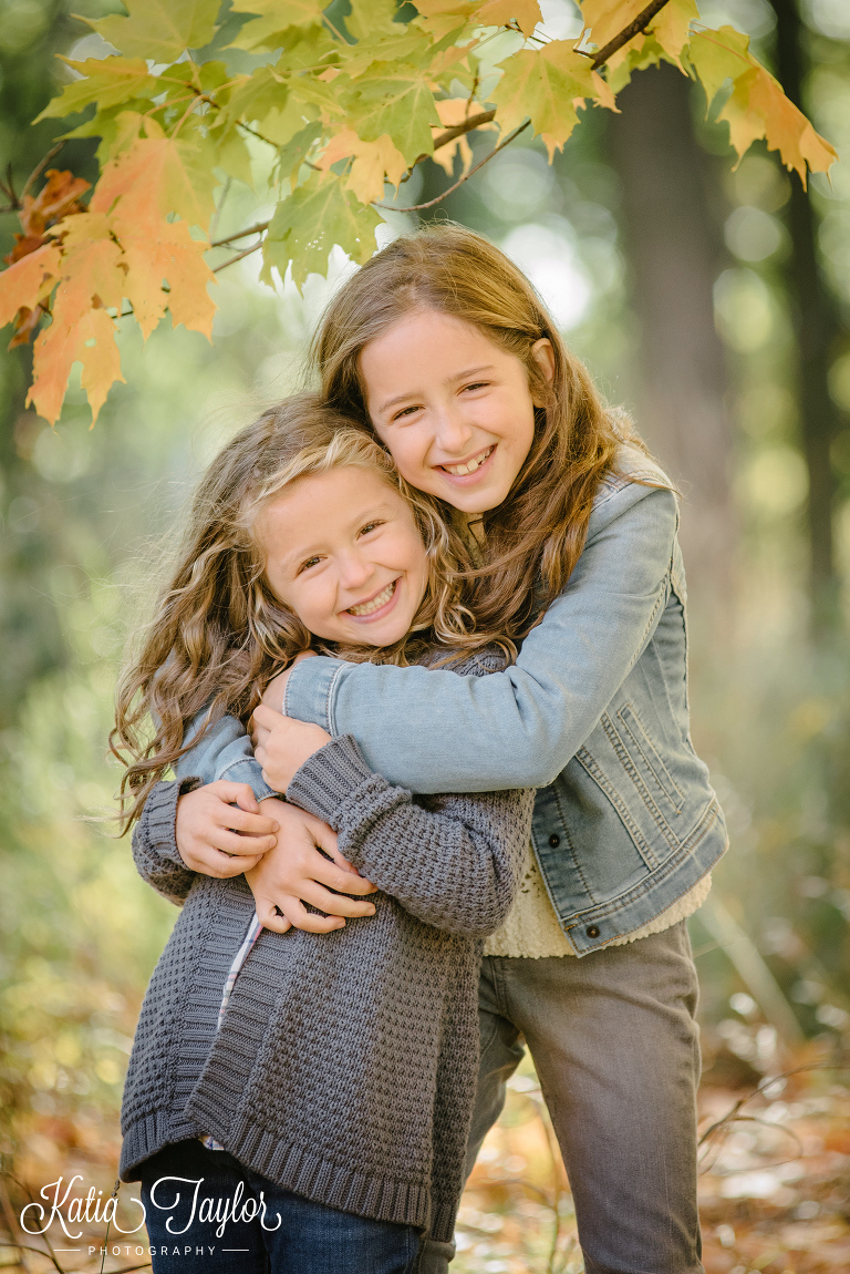 Two sisters hug in Toronto High Park for Fall photo shoot.