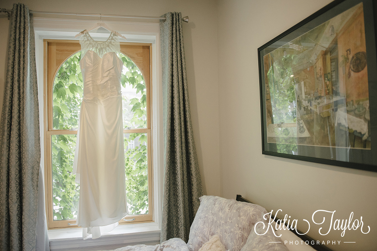 Brides wedding gown hanging in the window. www.katiataylorphotography.com