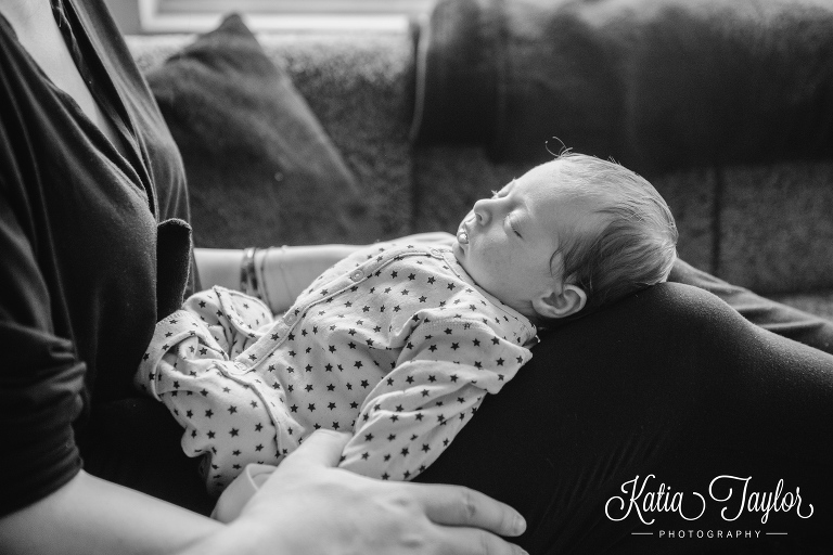 Newborn baby asleep on mother's lap. Toronto lifestyle newborn portraits. www.katiataylorphotography.com