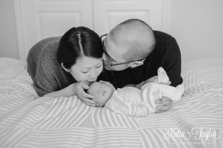 New parents kiss their baby boy. Toronto newborn photography.