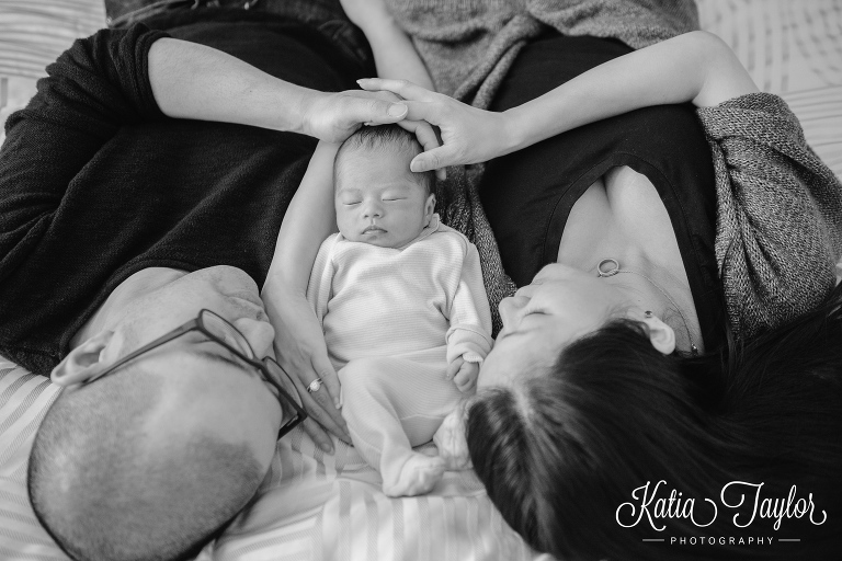 Mother and father cradle their newborn baby. Toronto newborn photography.