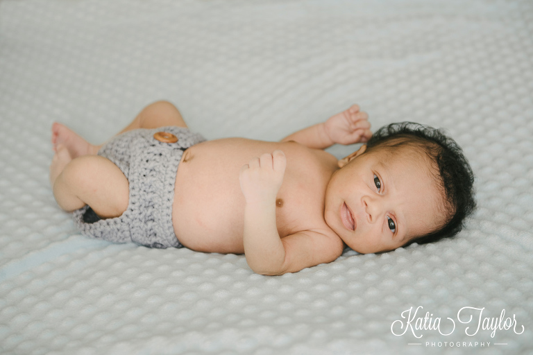 Newborn baby laying on a grey blanket. Toronto newborn portraits.