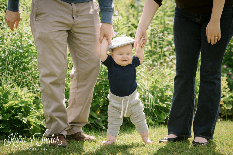 Parents help baby stand. Family photos, Edwards Garden, Toronto.