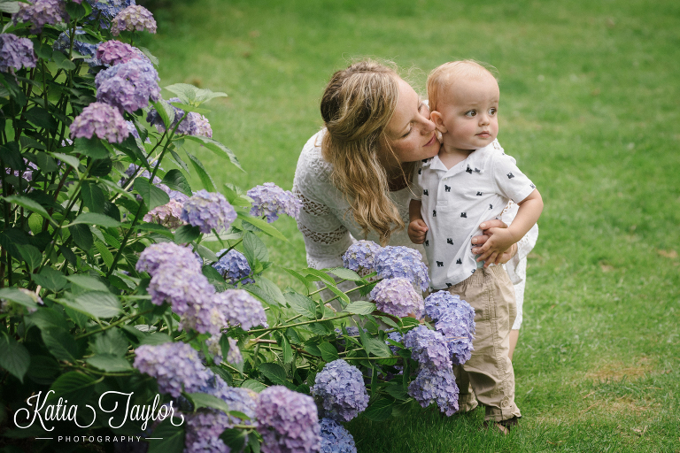 Mother kisses her son's cheek in the park. Toronto Family Photography. Brueckner Rhododendron Park