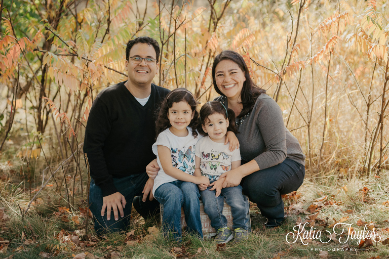 Mom, dad and 2 little girls in family portrait in the park.Toronto High Park Fall family portraits.