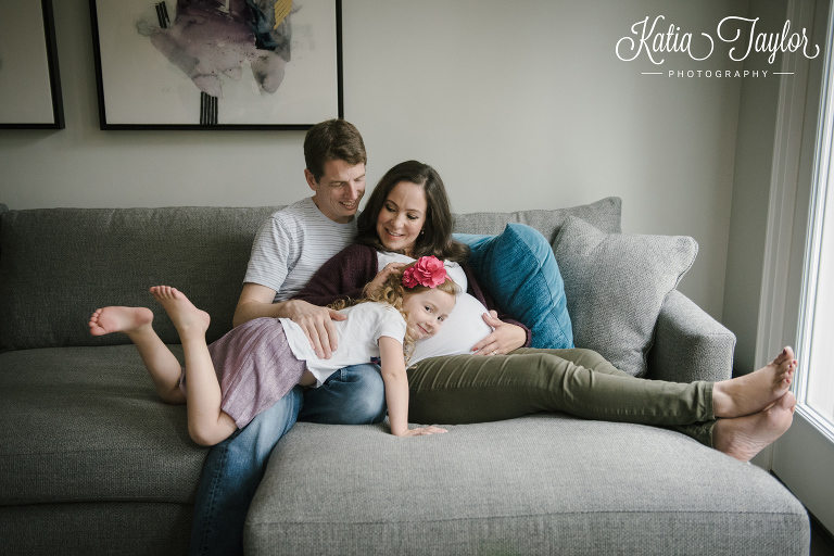 Big sister listening to mom's belly. Maternity portraits at home.