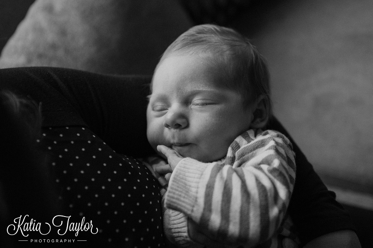 Sleeping baby boy in mothers arms. Toronto newborn portrait.