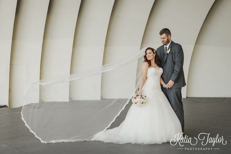 Stunning long veil on a bride with her gromm in a bandshell. Toronto FountainBlue wedding photography.