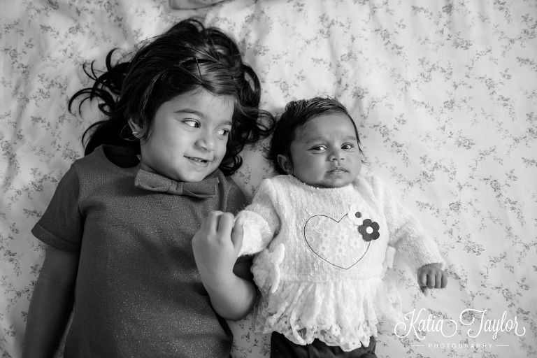 Lifestyle family portraits with 2-month-old baby and older sister.