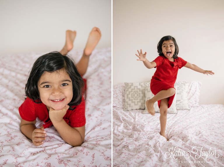 Lifestyle family portraits with big sister jumping on the bed.