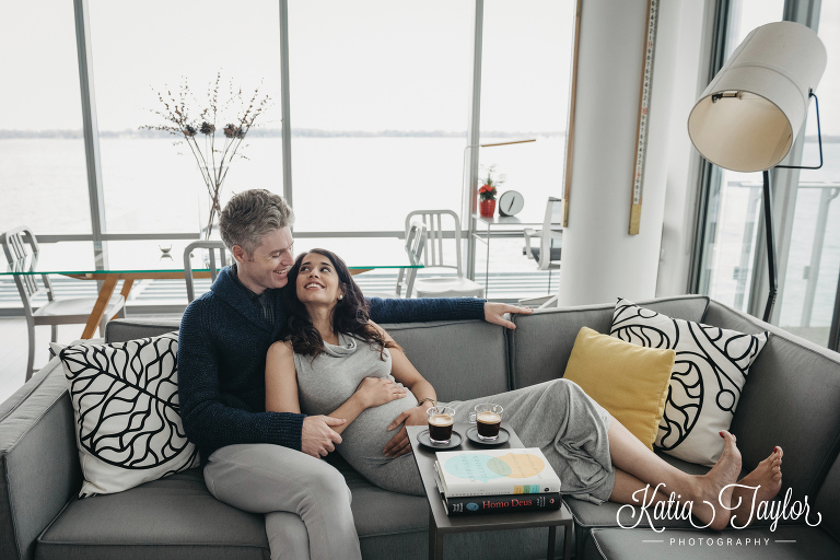 Parents-to-be relaxing with a coffee at home in their water-front condo. Maternity portraits in Toronto condo.