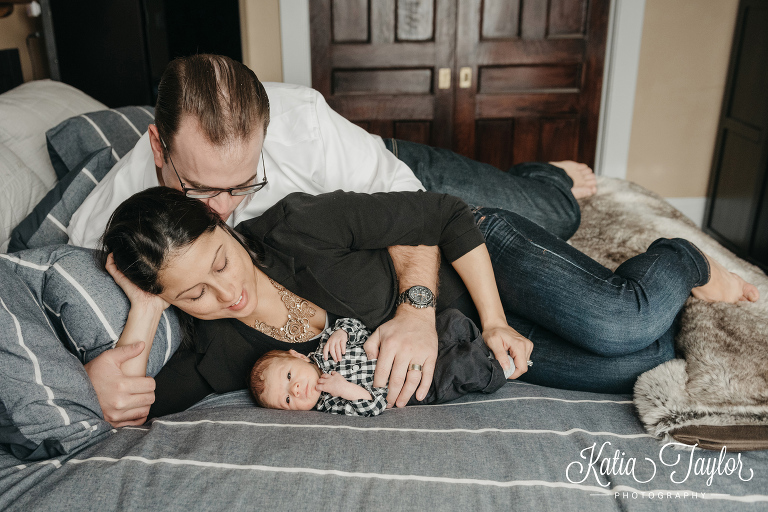 New parents snuggle with their newborn baby boy. Toronto lifestyle newborn photo shoot at home.