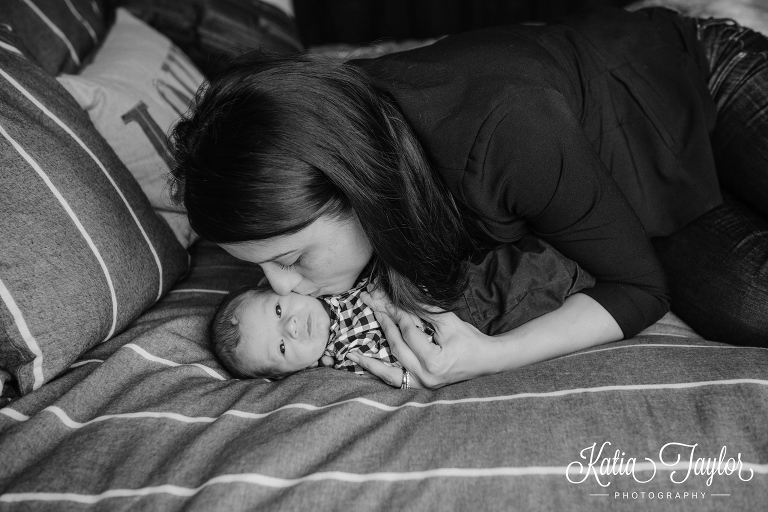 New mother give her little boy a kiss. Toronto lifestyle newborn photo shoot at home.