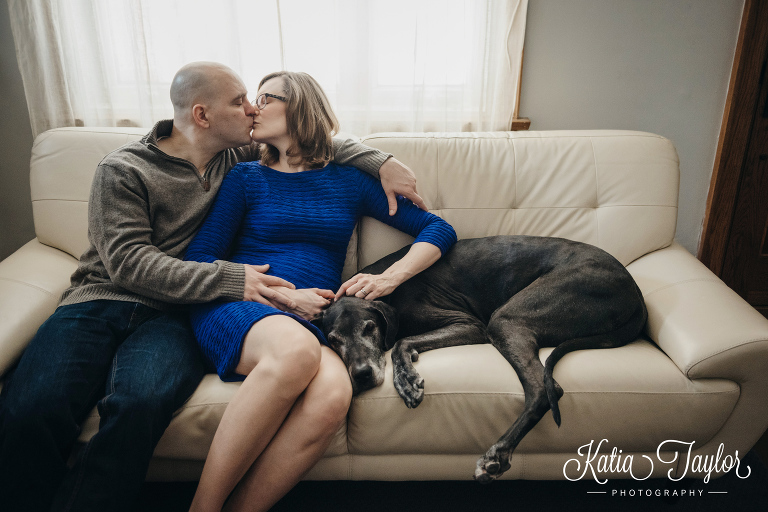 Pregnant couple on the couch with their great dane dog. Toronto lifestyle maternity photography.