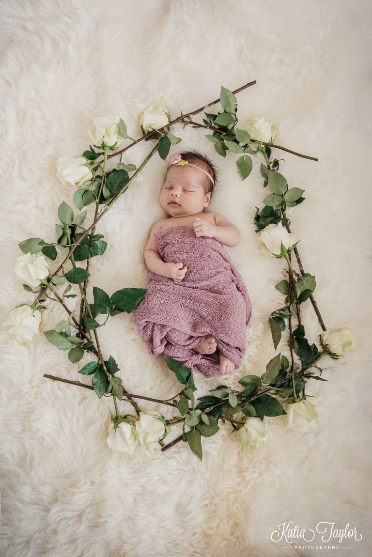 Sleeping baby girl surrounded by white roses. Toronto newborn photography.