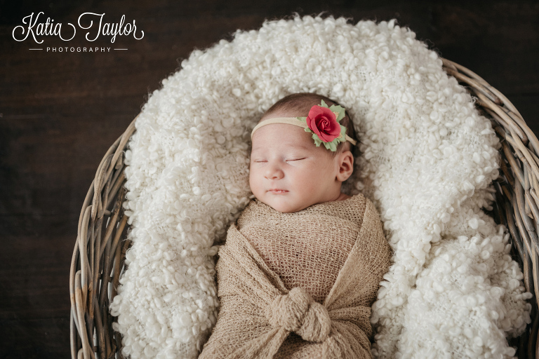 Newborn baby girl in a basket and beige wrap. Toronto newborn photography.