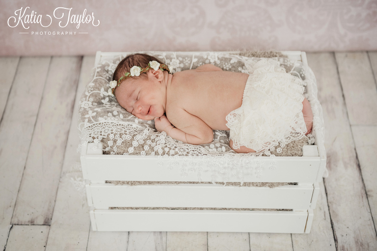 Newborn baby girl in a white crate with flower crown. Toronto newborn photography.