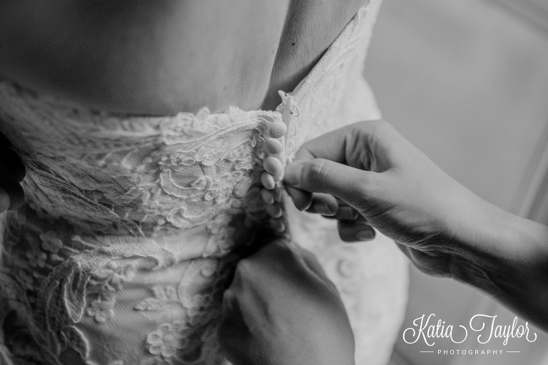 Detail of hands fastening a wedding dress. Toronto wedding photography.