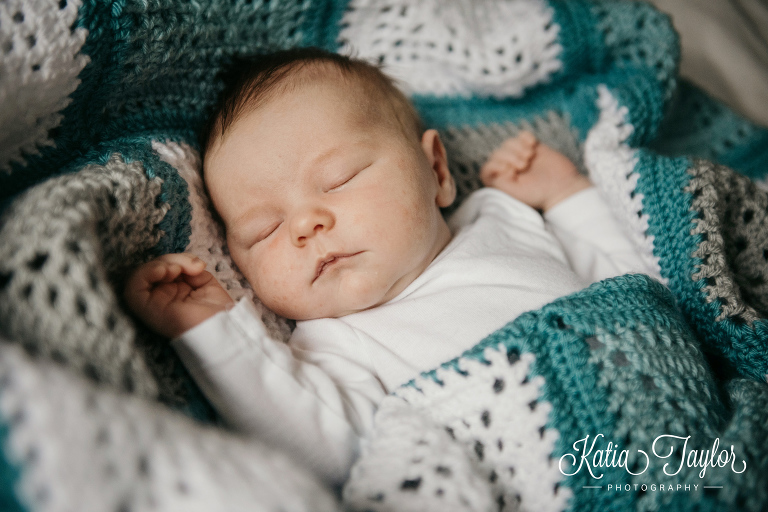 A sleeping baby wrapped in a crocheted blanket. Toronto newborn portraits.