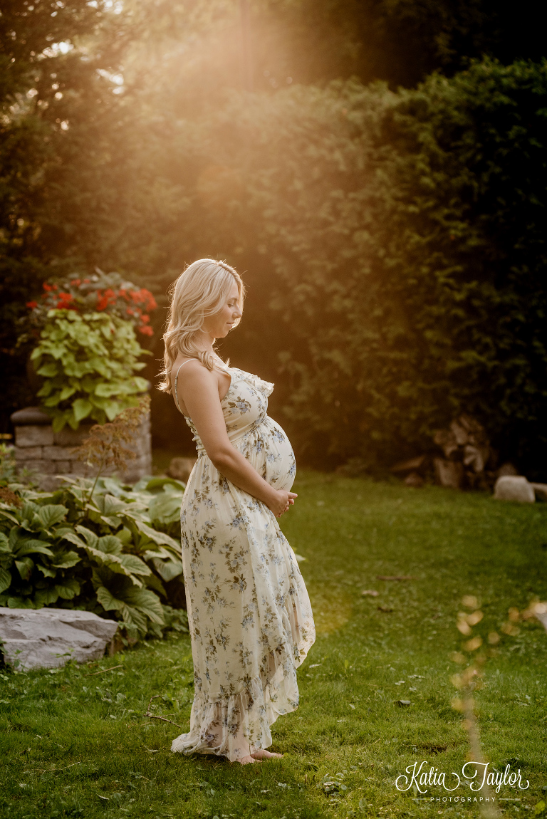 Beautiful golden sunset maternity portrait of woman in flower print maxi dress. Toronto maternity photography.