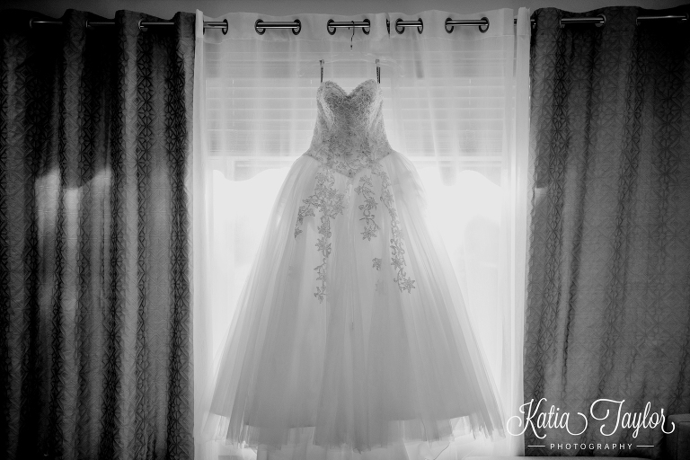 Wedding gown hanging in a window. Toronto wedding photography.