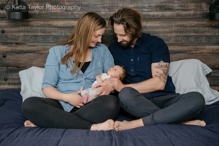 Couple with newborn baby boy in their bedroom