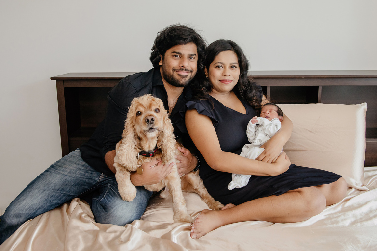 Newborn baby with his parents and dog at home