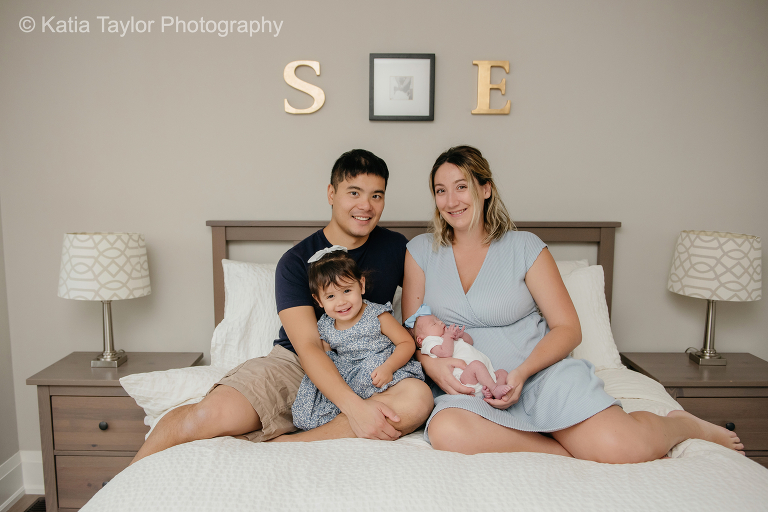 A newborn baby girl with her parents and older sister at home in Toronto