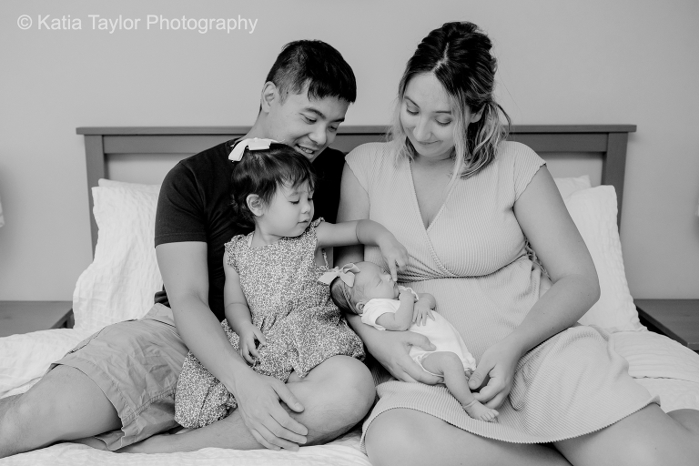 A newborn baby girl with her parents and older sister at home in Toronto