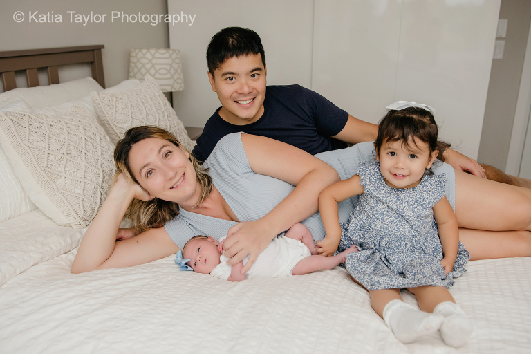 A newborn baby girl with her parents and older sister at home in Toronto