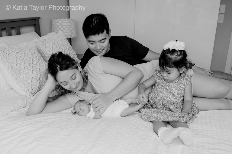 A newborn baby girl with her parents and older sister at home in Toronto