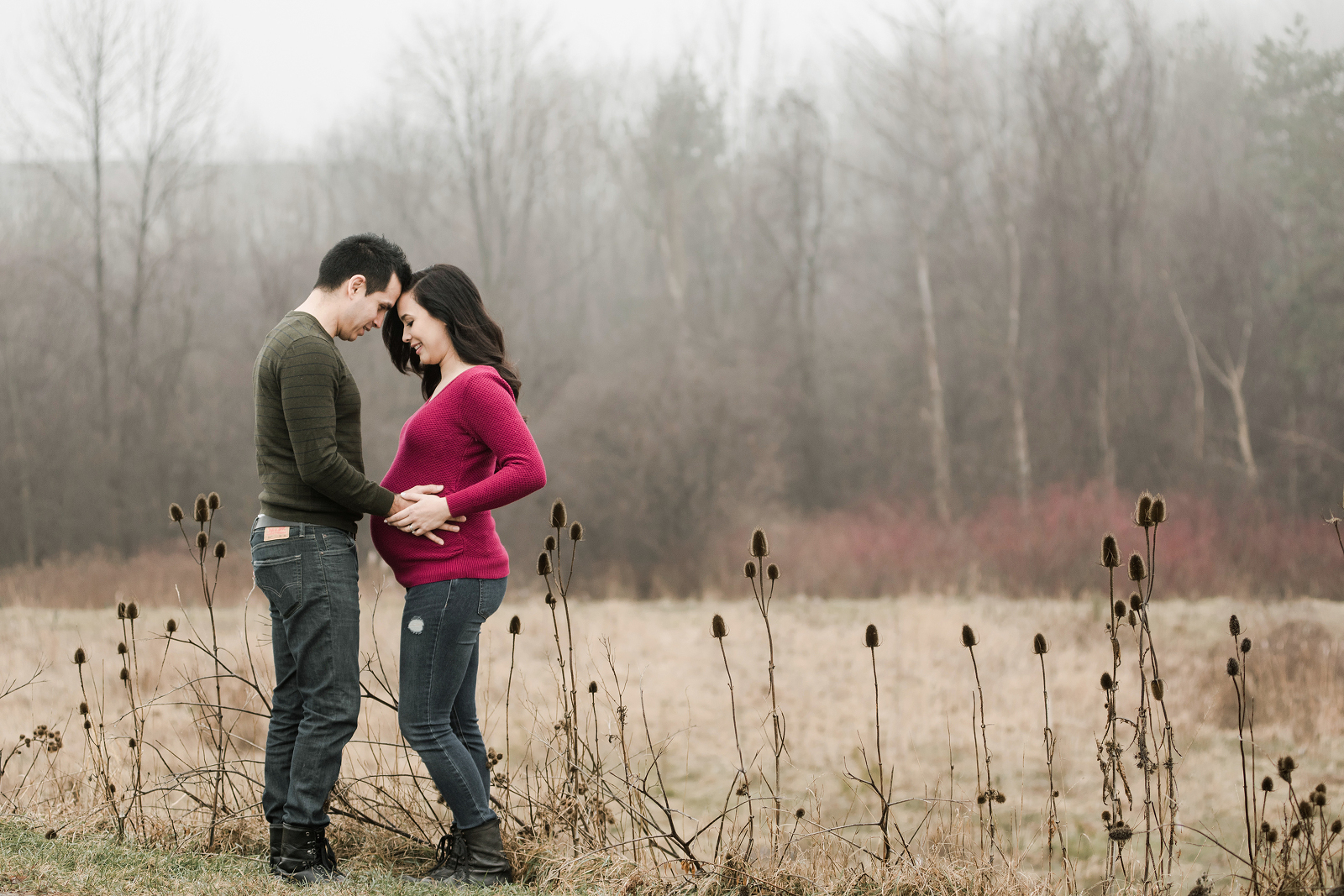 Maternity portrait of a couple in a foggy field.